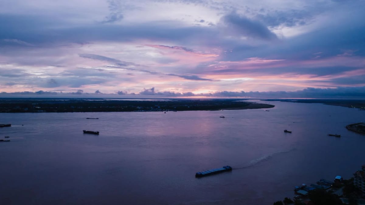 Le Mékong au crépuscule à Phnom Penh, barges de transport sur l'eau